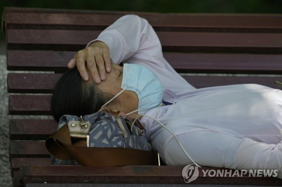 A resident wearing a mask naps on a bench, Monday, May 30, 2022, in Beijing. (AP Photo/Ng Han Guan) /사진=연합뉴스