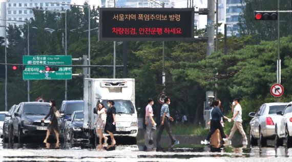 삼복더위의 두 번째 '중복'인 26일 오후 서울 여의도공원 앞 횡단보도에 아지랑이가 피어오르고 있다. 동해안을 제외한 전국 대부분으로 '폭염특보'가 내려진 가운데 서울 낮 기온 33도, 대구는 34도까지 치솟으며 무더위가 계속될 전망이다. 2022.7.26/뉴스1 © News1 임세영 기자