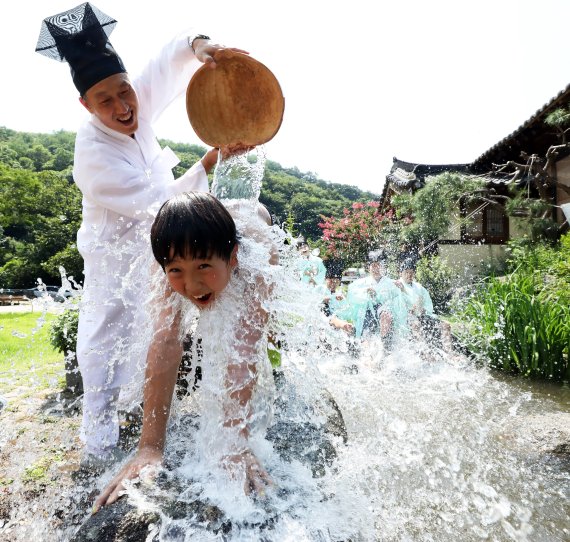 중복인 26일 전국에 폭염주의보가 내려진 가운데 충남 논산시 연산면 양지서당 '양지농촌유학센터'에서 공부하는 어린이들이 훈장 선생님의 등목으로 더위를 식히고 있다. 2022.7.26/뉴스1 © News1 김기남 기자