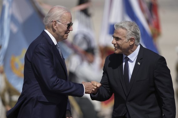 [텔아비브=AP/뉴시스] 조 바이든(가운데) 미국 대통령이 13일(현지시간) 이스라엘 텔아비브 벤구리온 국제공항에 도착해 야이르 라피드 총리와 주먹 인사를 하고 있다. 2022.07.14.