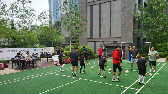 지난 7월 24일 서울 마포구에 위치한 신촌그랑자이 아파트에서 진행된 'FC서울과 함께하는 찾아가는 풋볼클래스' 행사에 참여한 입주민들이 축구 기술을 배우고 있다. GS건설 제공