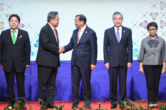 Cambodia's Foreign Minister Prak Sokhonn (C) shakes hands with South Korea?s Foreign Minister Park Jin (2nd L) as Japan?s Foreign Minister Yoshimasa Hayashi, China's Foreign Minister Wang Yi (2nd R) and Indonesia's Foreign Minister Retno Marsudi (R) pose for photos at the 23rd ASEAN Plus Three Forei