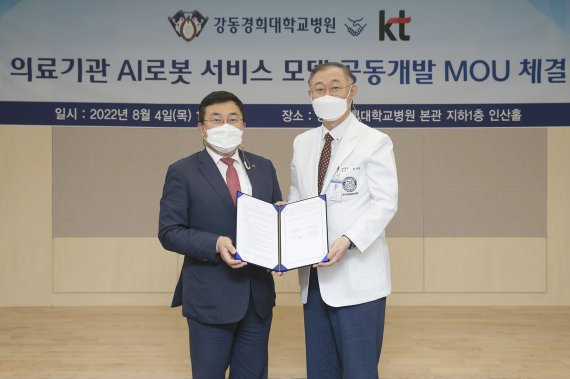 KT AI/DX융합사업부문장 송재호 부사장(왼쪽)과 강동경희대학교병원 김성완 원장(오른쪽)이 4일 강동경희대학교병원에서 의료기관 AI로봇 서비스 모델 공동개발 업무협약을 체결한 뒤 기념사진 촬영을 하고 있다. KT 제공