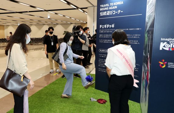 '김포~하네다' 국제선 노선의 운항이 재개된 6월29일 오후 서울 강서구 김포국제공항 입국장 앞에 마련된 한국관광웰컴센터에서 일본 입국객들이 한국 전통놀이를 체험하고 있다. (한국관광공사 제공) 2022.6.29/뉴스1