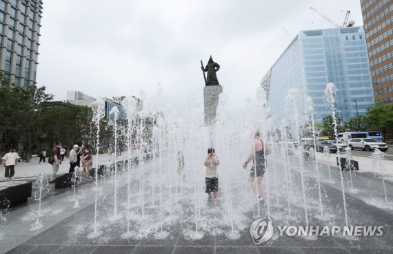 서울 광화문광장이 개장한 6일 오전 어린이 등이 분수대에서 더위를 식히고 있다.