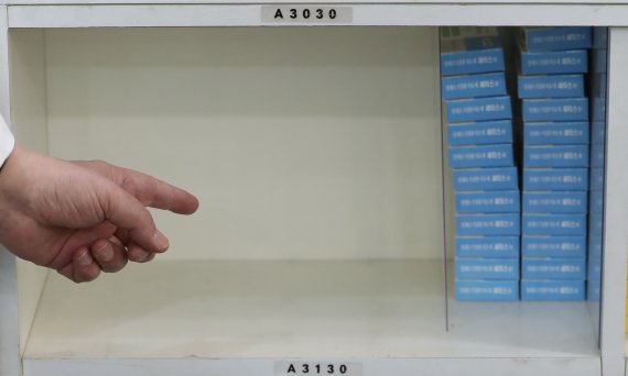 서울 한 약국에서 약사가 종합감기약이 다 팔린 후 텅 빈 선반을 가리키고 있다./뉴스1 ⓒ News1 이성철 기자