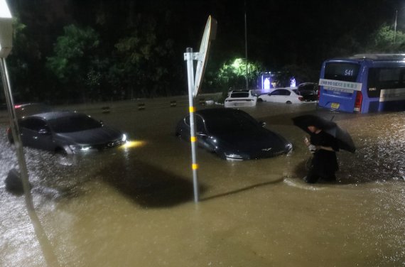 8일 서울 서초구 진흥아파트 인근 도로가 침수돼 차량이 물에 잠겨 있다. 뉴스1