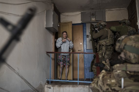 [하르키우=AP/뉴시스] 14일(현지시간) 우크라이나 하르키우에서 한 주민이 러시아군의 정보원을 체포하러 건물에 진입하는 우크라이나 보안국(SBU) 대원들을 보며 놀라고 있다. 2022.04.15.