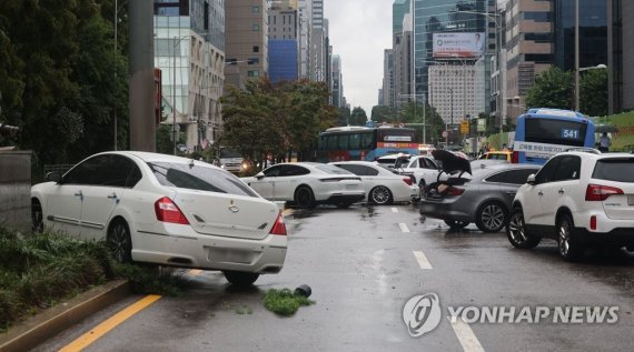 (서울=연합뉴스)9일 오전 서울 서초구 진흥아파트 앞 서초대로 일대에서 전날 내린 폭우에 침수됐던 차량들이 뒤엉켜 있다.