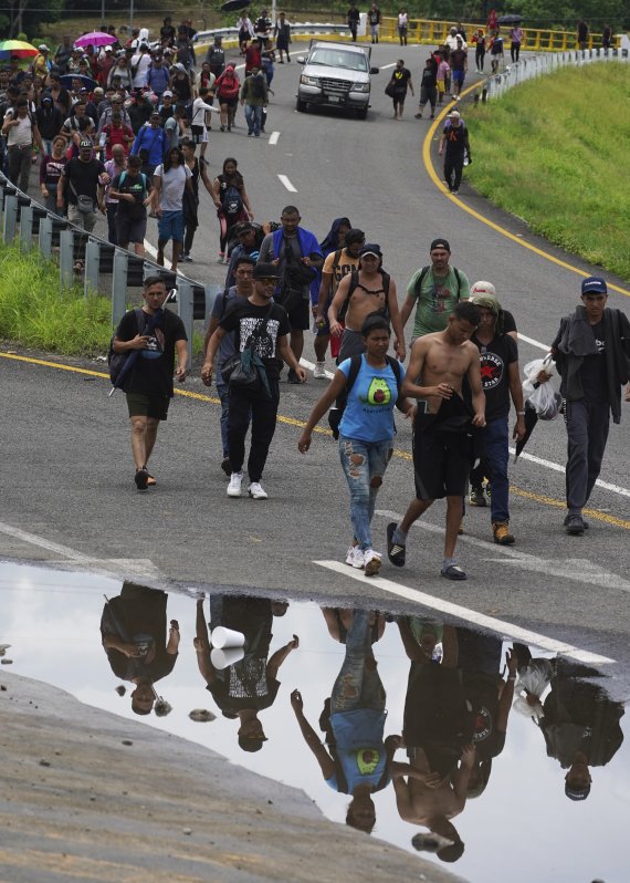 [타파출라=AP/뉴시스] 7일(현지시간) 멕시코 남부 치아파스주 타파출라에서 출발한 캐러밴 행렬의 이민자들이 미국 국경을 향해 걷고 있다. 2022.06.08.
