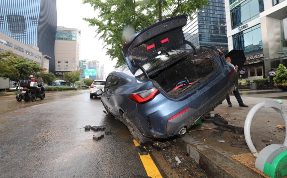 서울을 비롯한 중부지역에 기록적인 폭우가 내린 9일 오전 서울 서초구 서초동 진흥아파트 앞 서초대로에 전날 쏟아진 폭우에 침수, 고립된 차량이 인도위 자전거거치대에 올라서 있다. 2022.8.9/뉴스1 ⓒ News1 박세연 기자