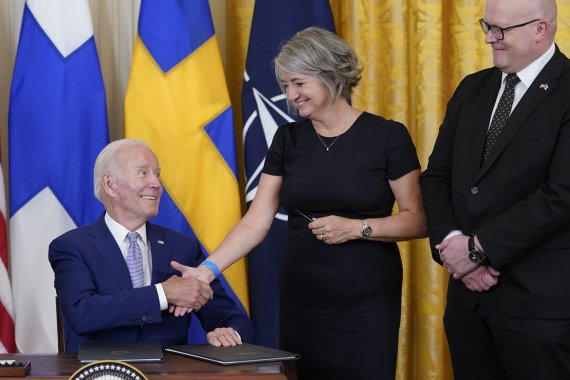 [워싱턴=AP/뉴시스] 조 바이든 미국 대통령이 9일(현지시간) 백악관 이스트룸에서 핀란드·스웨덴의 북대서양조약기구(NATO·나토) 가입 비준안에 서명한 뒤 카린 올롭스도터 주미스웨덴 대사와 악수하고 있다. 오른쪽은 미코 하우탈라 주미핀란드 대사. 2022.08.10.