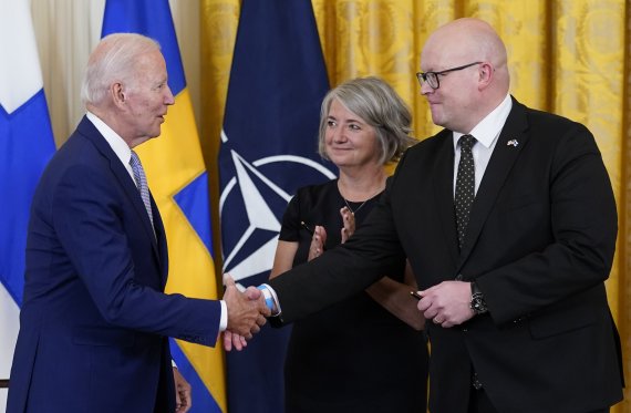 [워싱턴=AP/뉴시스] 조 바이든 미국 대통령이 9일(현지시간) 백악관 이스트룸에서 핀란드·스웨덴의 북대서양조약기구(NATO·나토) 가입 비준안에 서명한 뒤 미코 하우탈라 주미핀란드 대사와 악수하고 있다. 가운데는 카린 올롭스도터 주미스웨덴 대사. 2022.08.10.