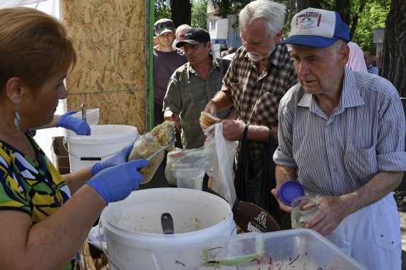 [자포리자=AP/뉴시스] 9일(현지시간) 우크라이나 자포리자에 있는 인도적 구호물자 배급소에서 주민들이 음식을 받고 있다. 2022.08.10.