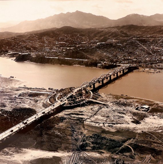 [사진 속 어제와 오늘] 한강 다리 ① 한강 다리 최초 인도교인 제1 한강교(현 한강대교)와 노들섬. 국내 광고사진가 1세대인 김한용이 육군 종군사진기자로 활동하던 시절 촬영했다. 1968년 한강소교 아래 백사장이 제거돼 노들섬은 완전한 하중도가 됐다. 1981년 신교가 완공돼 지금의 쌍둥이 다리가 됐다. 1966년 [서울역사박물관 제공]