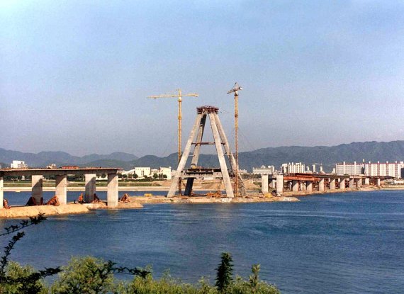 [사진 속 어제와 오늘] 한강 다리 ① 올림픽 대교 건설 광경. 1985년 11월 착공해 1990년 6월에 완공했다. 2001년 주탑 꼭대기 조형물 설치작업을 하던 육군 헬기가 추락해 3명이 순직한 아픔이 있다. 1988년. [연합뉴스 자료사진]