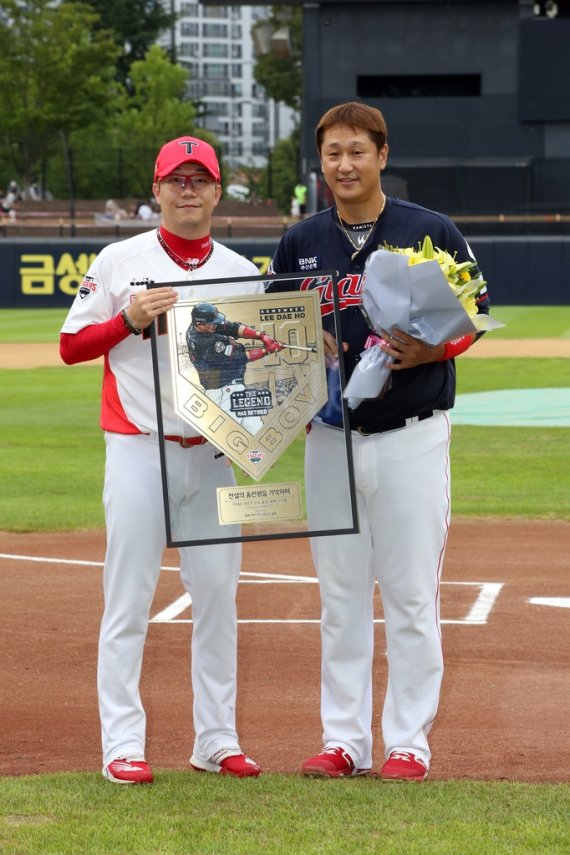 이대호에게 기념 동판 액자 전달하는 양현종 (서울=연합뉴스) KIA 타이거즈 양현종이 13일 광주 기아챔피언스필드에서 열린 '이대호 은퇴 투어' 행사에서 롯데 이대호에게 기념 동판 액자를 전달하고 있다. [KIA 타이거즈 제공. 재판매 및 DB금지]