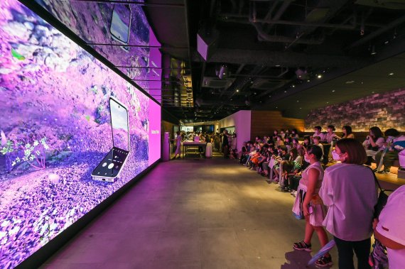 13일 일본 도쿄의 갤럭시 하라주쿠(쇼케이스)에서 소비자들이 '갤럭시Z플립4 X BTS' 디지털 영상을 관람하고 있다. 삼성전자 제공