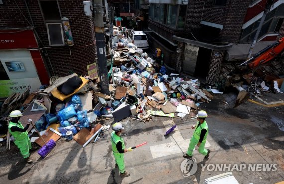 골목 메운 수해 흔적 골목 메운 수해 흔적 (서울=연합뉴스) 류영석 기자 = 14일 오후 서울 관악구 신사동 일대 수해 피해 현장에서 환경미화원들이 굴삭기를 이용해 복구 작업을 하고 있다. 2022.8.14 ondol@yna.co.kr (끝)