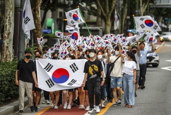 [서울=뉴시스] 정병혁 기자 = 제77주년 광복절인 15일 오전 서울 종로구 종로구청 앞에서 시민들이 태극기를 들고 보신각으로 행진하고 있다. 2022.08.15. jhope@newsis.com