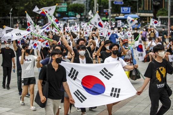 [서울=뉴시스] 정병혁 기자 = 제77주년 광복절인 15일 오전 서울 종로구 종로구청 앞에서 시민들이 태극기를 들고 보신각으로 행진하고 있다. 2022.08.15. jhope@newsis.com