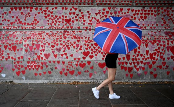 16일(현지시간) 영국 런던에서 한 행인이 국립 코로나19 추모 벽을 지나고 있다.EPA연합뉴스