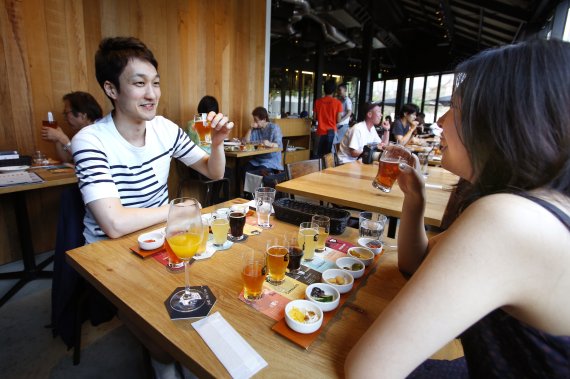 [도쿄=AP/뉴시스]일본 정부가 코로나19로 침체된 경기를 부양하기 위해 청년들에게 음주를 장려하고 사실상 술 권하는 사회를 만들고 있다. 자료사진은 2017년 7월 도쿄의 한 맥주집 '스프링밸리' 양조장에서 젊은이들이 맥주를 마시는 모습.2022.08.18.
