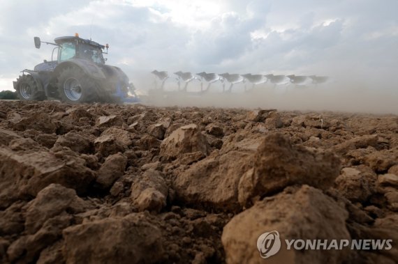프랑스의 한 농장에서 작업 중이 농민 A farmer drives a tractor amid a cloud of dust, as he works in a field during a drought in Blecourt, France, August 17, 2022. REUTERS/Pascal Rossignol