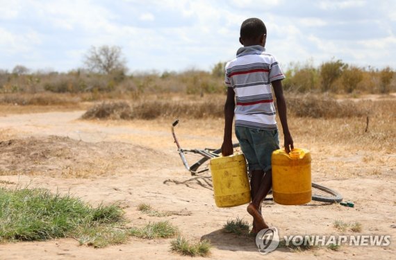 케냐서 물 양동이를 들고 걸어가는 소년 (220615) -- KILIFI, June 15, 2022 (Xinhua) -- A boy carries buckets of water in Kidemu sub-location in Kilifi County, Kenya, March 23, 2022. The Horn of Africa drought has thrust at least 18.4 million people, including more than 7.1 million acutely malnourished children, into s