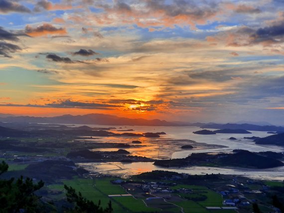 다도해 일출 디테일. 강렬한 해가 검은 섬과 은빛 바다, 회색 갯벌을 붉게 물들이기 시작한다 ⓒ 뉴스1