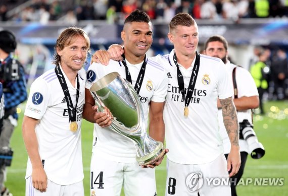 맨체스터 유나이티드 이적설이 불거진 카세미루(가운데) epa10114932 (L-R) Luka Modric, Casemiro and Toni Kroos of Real Madrid celebrate with the trophy after winning the UEFA Super Cup soccer match between Real Madrid and Eintracht Frankfurt at the Olympic Stadium in Helsinki, Finland, 10 August 2022. EPA/Petteri Paalasmaa