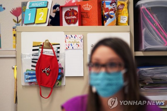 Virus Outbreak Texas School Masks FILE - Wearing a mask to protect against the spread of COVID-19, kindergarten teacher Amber Ximenz prepares her classroom at Southside Independent School District in San Antonio, on Aug. 13, 2020. Texas Gov. Greg Abbott’s executive order that forbids school district
