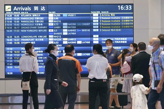 [도쿄=AP/뉴시스] 23일 일본 도쿄의 하네다 공항 입국장에서 마스크를 쓴 사람들이 승객 도착을 기다리고 있다. 기시다 후미오 일본 총리는 9월 7일부터 최소 3차까지 백신 접종을 받은 여행자는 입국 시 코로나19 유전자증폭(PCR) 검사 음성 증명서를 제출하지 않아도 되고 입국자 상한선도 늘릴 것이라고 24일 밝혔다. 2022.08.24.