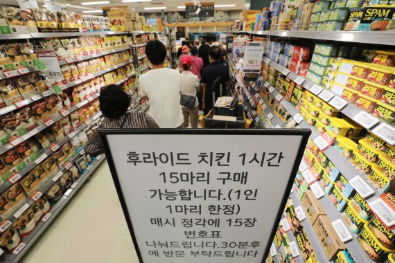 고물가 시대에 대형마트들이 잇따라 반값 치킨 상품을 내놓으며 초처가 치킨 경쟁을 벌이고 있는 21일 서울 이마트 용산점을 찾은 고객들이 한 마리에 5천980원짜리 치킨을 사기 위해 줄을 서서 기다리고 있다. 2022.8.21/뉴스1 ⓒ News1 이광호 기자