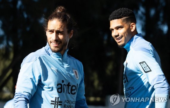 카세레스(왼쪽)와 로날드 아라우호 epa09229900 A handout photo made available by the Uruguayan Football Association (AUF) showing the players Martin Caceres (L) and Ronald Araujo during a training session, at the Celeste Complex, on the outskirts of Montevideo, Uruguay, 26 May 2021. A small group of soccer players 
