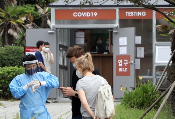 14일 오후 제주국제공항 주차장에 설치된 외국인 코로나19 검사센터에 서 한 외국인 관광객들이 안내를 받고 있다. 한국공항공사 제주본부는 제주공항 국제선 재개 및 최근 코로나 확산에 대비해 이날부터 공항 내에서 코로나 검사센터를 운영하고 있다.2022.7.14/뉴스1 ⓒ News1 고동명 기자