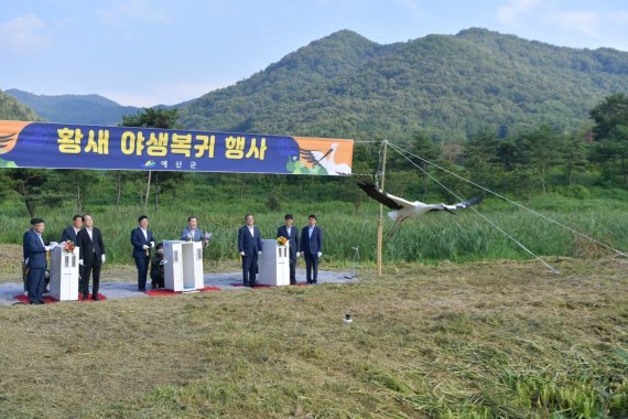 얘산군과 충남교육청 관계자들이 예산황새공원에서 황새 야생복귀 행사를 갖고 있다.