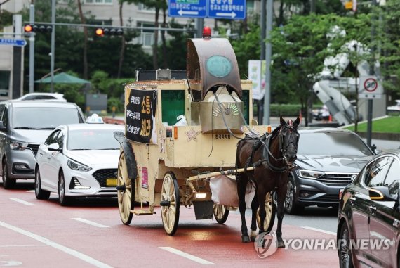 카카오게임즈의 '우마무스메:프리티 더비' 국내 이용자들이 게임사 측의 운영 방침에 반발하는 항의 문구 현수막을 붙인 마차가 29일 오전 카카오게임즈 본사가 위치한 경기도 성남시 판교역 인근 도로를 달리고 있다. 연합뉴스