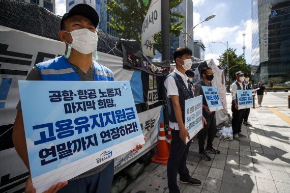 [서울=뉴시스] 정병혁 기자 = 공공운수노조 공항·항공본부 노동자들이 지난해 9월8일 오전 서울 중구 서울지방고용노동청 앞에서 열린 고용유지지원금 연장, 부당해고 판정 노동자 즉각 복직 촉구 기자회견에서 피켓을 들고 있다. 2021.09.08. jhope@newsis.com