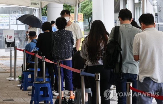 30일 오전 시민들이 서울 마포구 보건소 선별진료소에서 코로나19 검사를 위해 차례를 기다리고 있다. 중앙방역대책본부는 이날 0시 기준 신규확진자 수가 11만 5638명이라고 발표했다. 연합뉴스 제공.