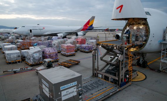 인천국제공항 아시아나항공 화물터미널에서 14일 관계자가 화물을 옮기고 있다. 신종 코로나바이러스 감염증(코로나19) 장기화 국면에서도 아시아나는 3분기 영업이익이 전년 대비 2680% 늘어나는 기대 이상의 성과를 냈다. 항공화물 운임 강세 및 화물량 증가 효과 때문이다. 인천국제공항공사 역시 개항 20년 만에 누적 화물 5000만톤, 연간 항공화물 300만톤을 달성했다. 연간 항공화물 300만톤 달성은 전 세계 공항 중 홍콩 첵랍콕 공항에 이어 2번째다. 2021.12.19/뉴스1 ⓒ News1 안은나 기자