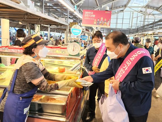 김신남 전남도 도민안전실장이 31일 나주 영산포 풍물시장에서 안전사고 예방 캠페인 등을 실시한 후 전통시장 활성화를 위한 장보기 행사 일환으로 물건을 사고 있다. 사진=전남도 제공