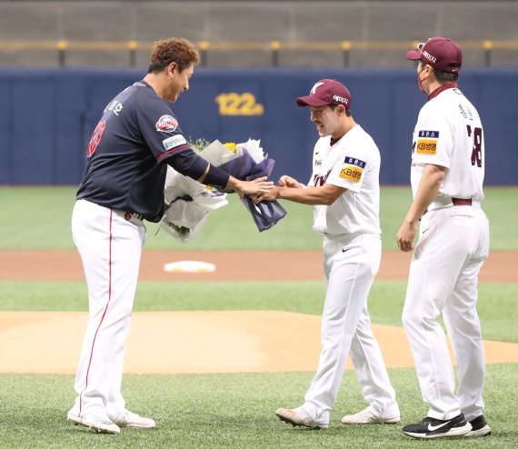 [서울=뉴시스] 조수정 기자 = 롯데 자이언츠 이대호가 31일 오후 서울 구로구 고척스카이돔에서 2022 KBO리그 롯데 자이언츠와 키움히어로즈 경기에 앞서 열린 다섯번째 은퇴투어에서 키움 히어로즈 홍원기 감독과 이용규 선수로부터 해바라기 꽃다발을 전달받고 있다. 이대호 선수를 언제나 응원하고 늘 승승장구 하기를 바라는 의미를 담아 일편단심, 행운, 그리움, 동경 등의 꽃말을 가진 해바라기를 전달했다. 2022.08.31. chocrystal@newsis.com