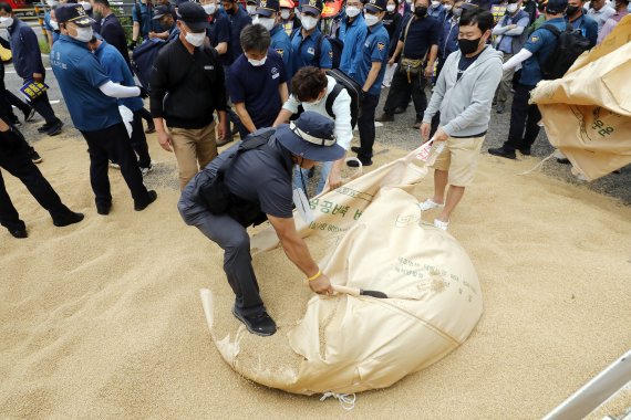 한국후계농업경영인중앙연합회 등 주요 농민 단체가 29일 서울 용산구 서울역 인근에서 농가경영 불안 해소 대책 마련 촉구 농민 총궐기를 마치고 정부 대책에 항의하며 쌀을 버리고 있다. 2022.08.29. photocdj@newsis.com /사진=뉴시스