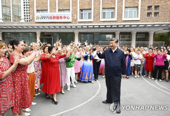지난 2022년 7월 13일 8년 만에 신장 위구르 자치구를 방문한 시진핑 중국 국가 주석이 우루무치의 한 마을에서 주민들에게 환영을 받으며 걸어가고 있다. 신화통신연합뉴스