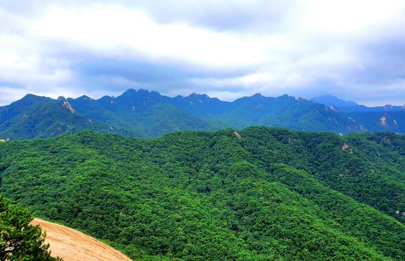 사패산에서 바라본 도봉산의 병풍처럼 펼쳐진 스카이라인. 오른쪽에 북한산 백운대가 구름에 가리우고 있다