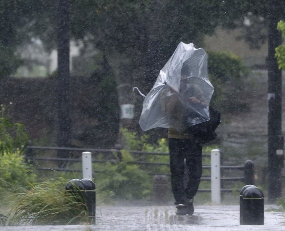 (오키나와 교도=연합뉴스) 제11호 태풍 '힌남노'가 접근하는 가운데 3일 일본 오키나와현 나하시에서 우산을 쓴 남성이 강한 바람을 맞으며 이동하고 있다. 2022.9.4 /사진=연합뉴스