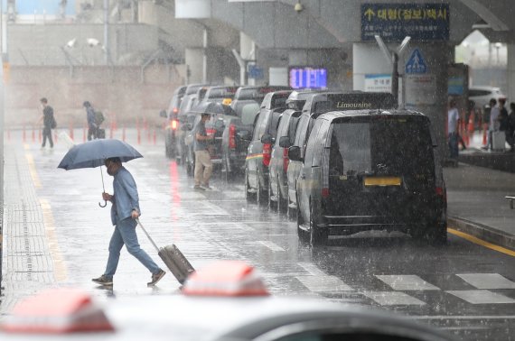 제11호 태풍 '힌남노'가 북상 중인 4일 오후 제주국제공항에서 관광객들이 비를 피해 이동하고 있다. 뉴시스 제공