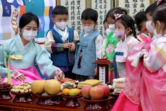 추석 연휴를 나흘 앞둔 5일 서울 서초구 농협 하나로마트 양재점에서 오색 한복을 차려입은 어린이들이 추석 차례상을 배우고 있다. /뉴스1