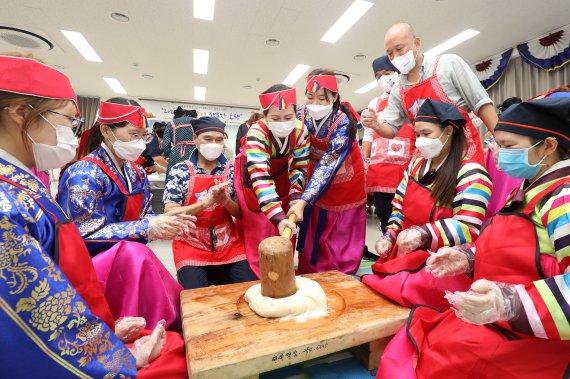 5일 오전 대구 달서구가족센터에서 열린 '2022 추석맞이 행복한 동행' 행사에서 한복을 차려입은 결혼이민자들이 인절미를 만들기 위해 떡메치기 체험을 하고 있다. /뉴스1